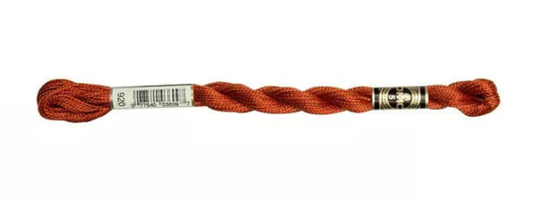 Orange embroidery floss spool with a label on a white background